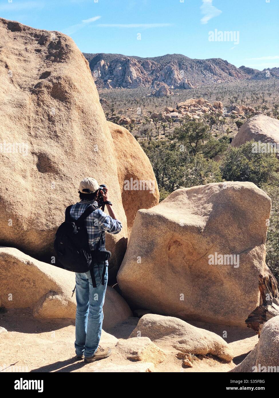 Un fotografo che ammirano le formazioni rocciose nel parco nazionale joshua Tree Foto Stock