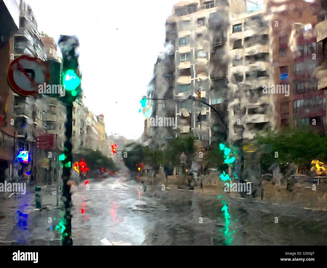 urbanscape in una giornata piovosa attraverso una finestra bagnata Foto Stock