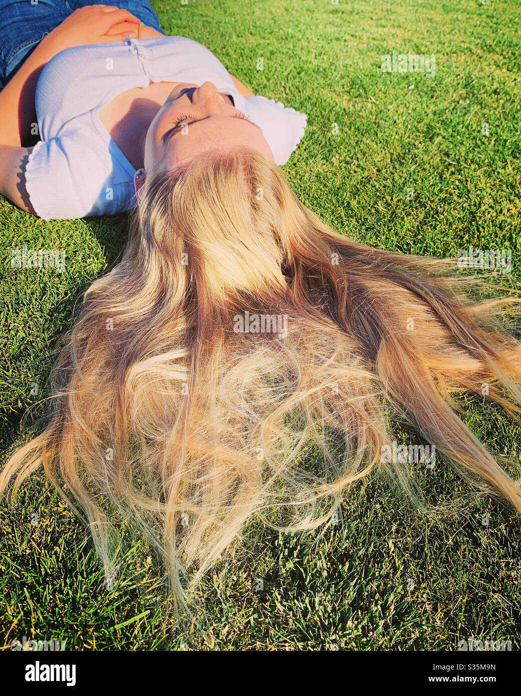 Ragazza con capelli biondi sdraiati Foto Stock