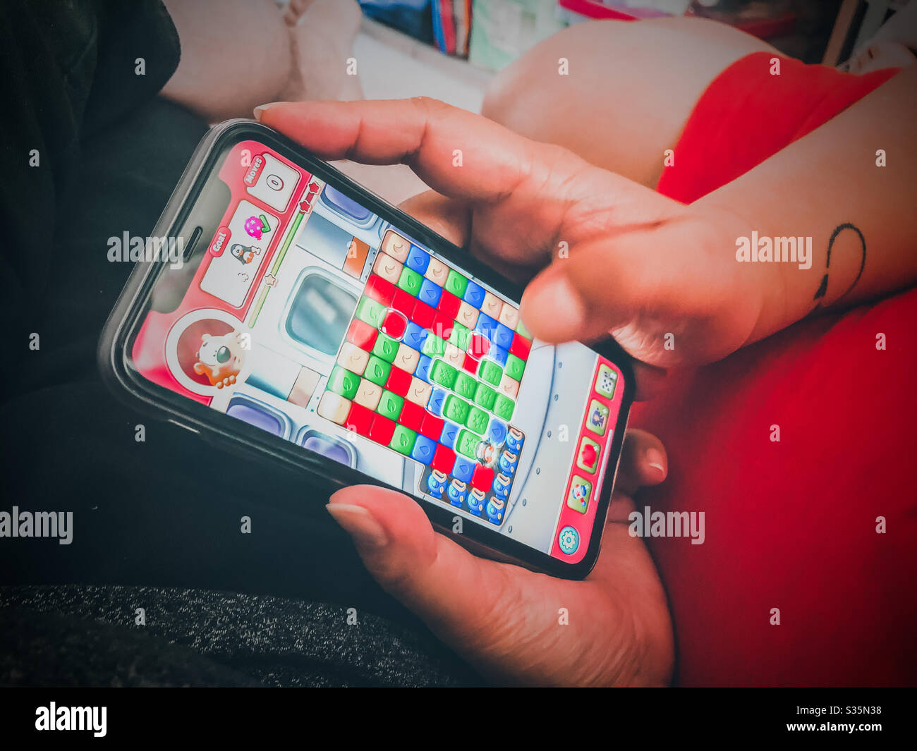 Una donna che gioca sul suo cellulare. Foto Stock