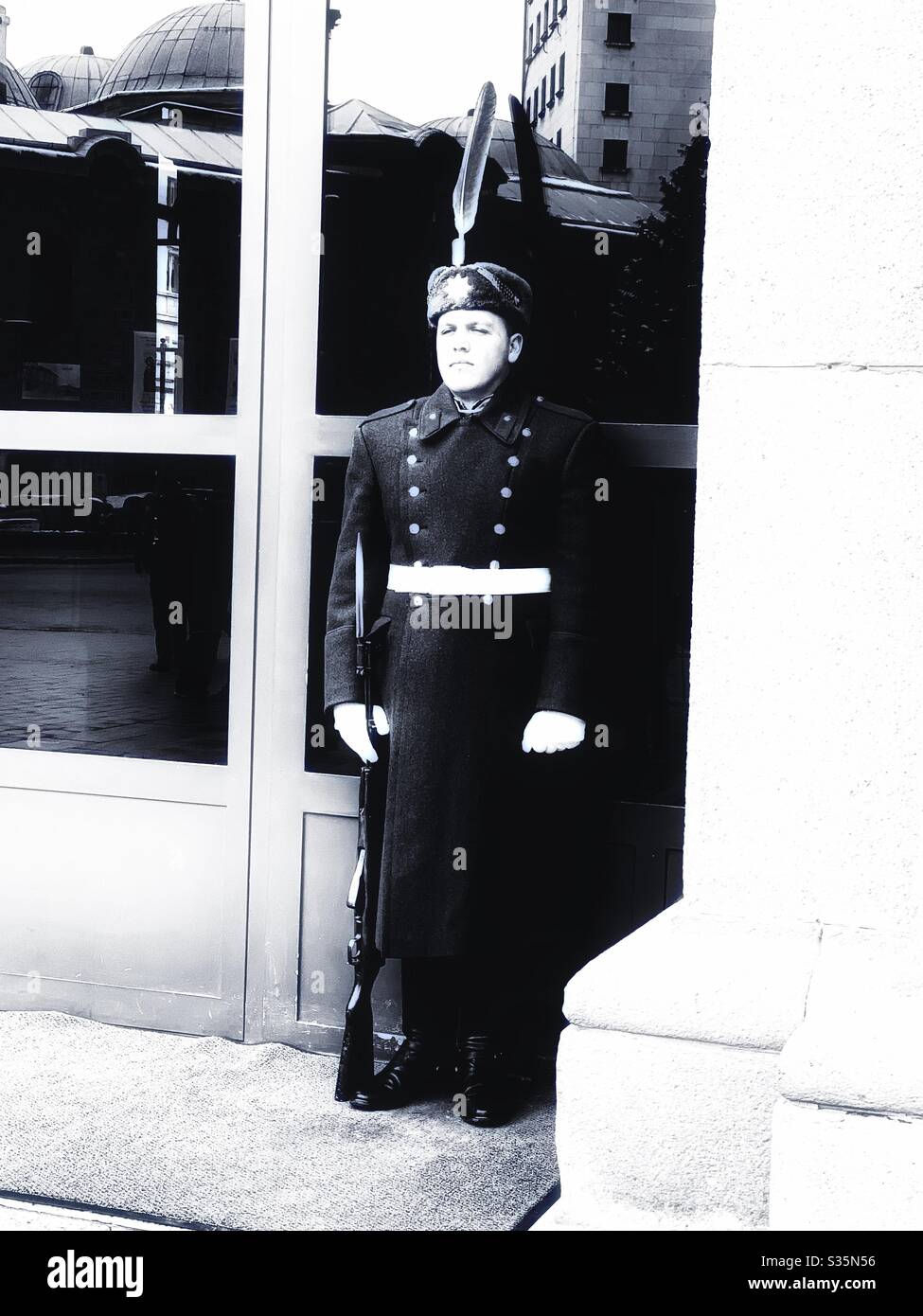 Monocromatico: Una guardia presidenziale bulgara si trova fuori dall'ingresso in uniforme. Sofia, Bulgaria. - Immagine stock catturata con smartphone