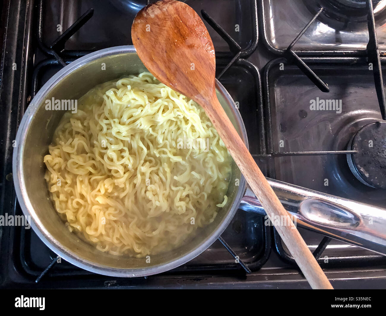 Una pentola di tagliatelle istantanee che cucinano su un fornello a gas. Foto Stock