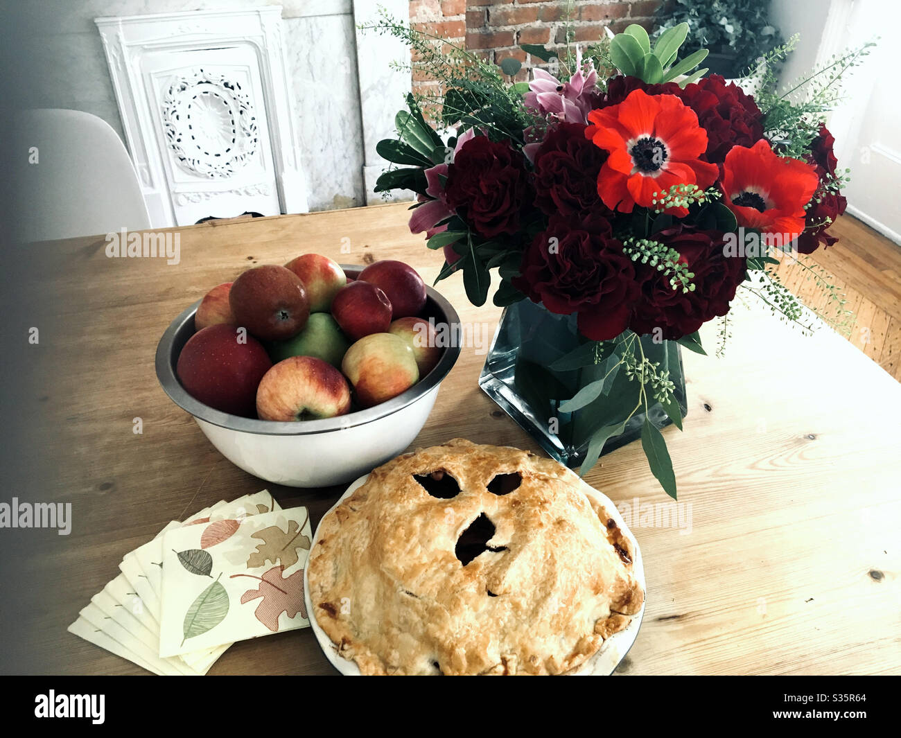 Natura morta autunnale di mele appena raccolte, torta di mele e bouquet floreale su un tavolo. - Immagine stock catturata con smartphone