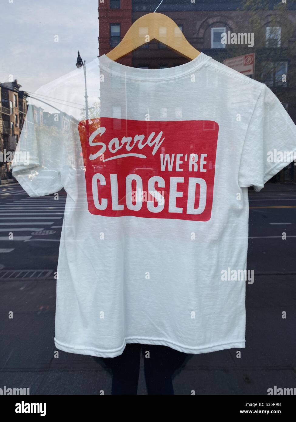 28 aprile 2020: Cartello chiuso stampato su una t-shirt appesa in un negozio, Park Slope, Brooklyn, New York, USA. - Immagine stock catturata con smartphone