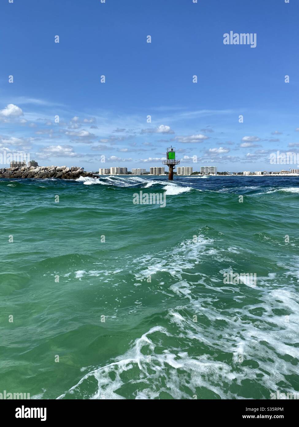 Vista in barca del marcatrice sul molo e vista remota degli edifici sulla spiaggia - Immagine stock catturata con smartphone
