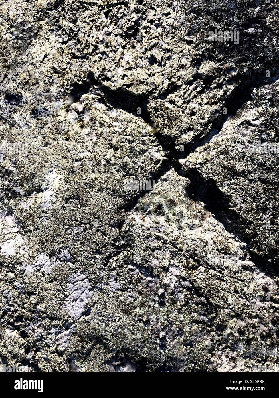 X marchio scolpito in pietra da ingresso alla grotta. X contrassegna il punto. Foto Stock