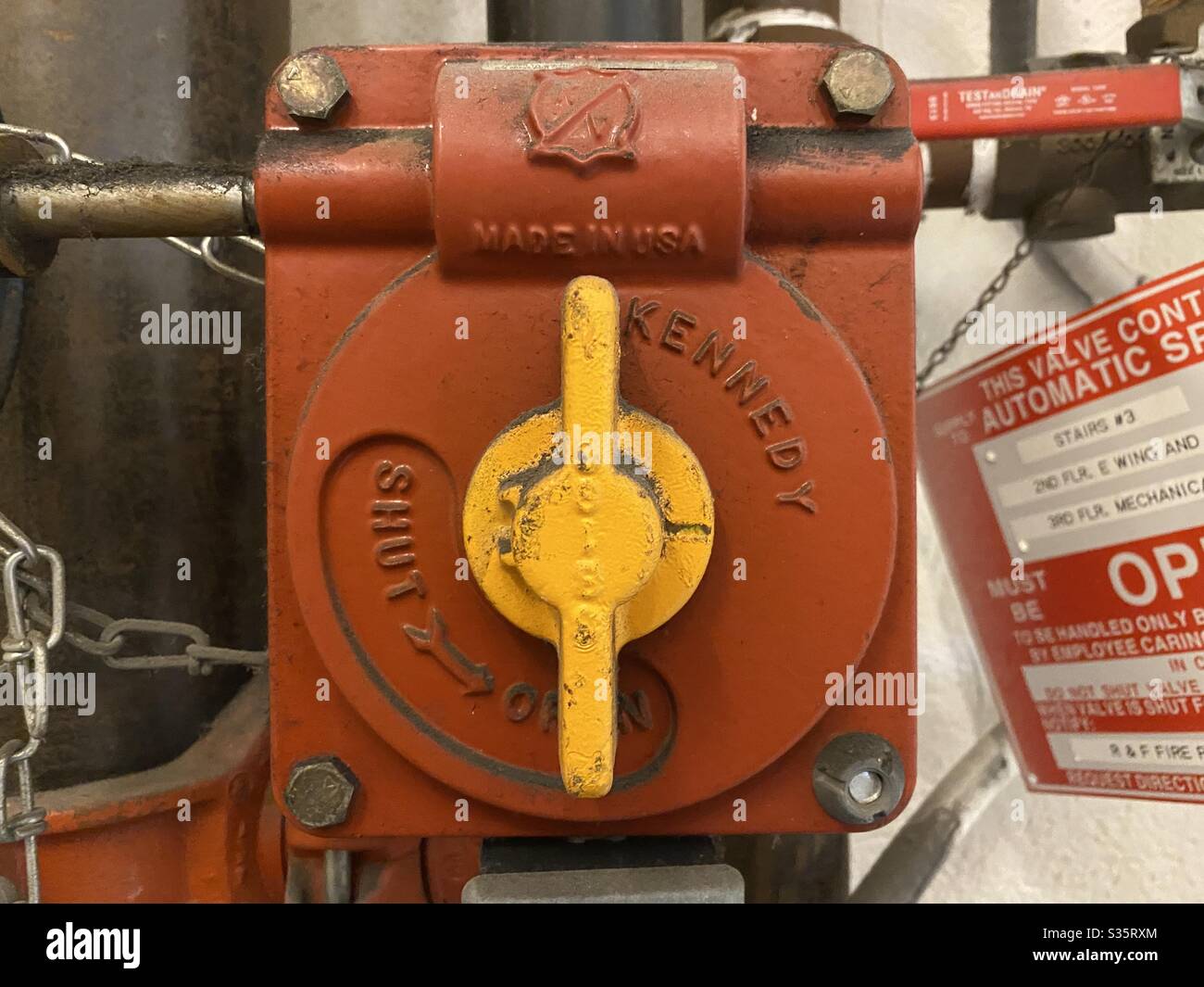 LOS ANGELES, CA, Apr 2020: Dettaglio del controllo della valvola di chiusura rossa con rubinetto giallo brillante, parte del sistema antincendio nell'edificio storico Foto Stock