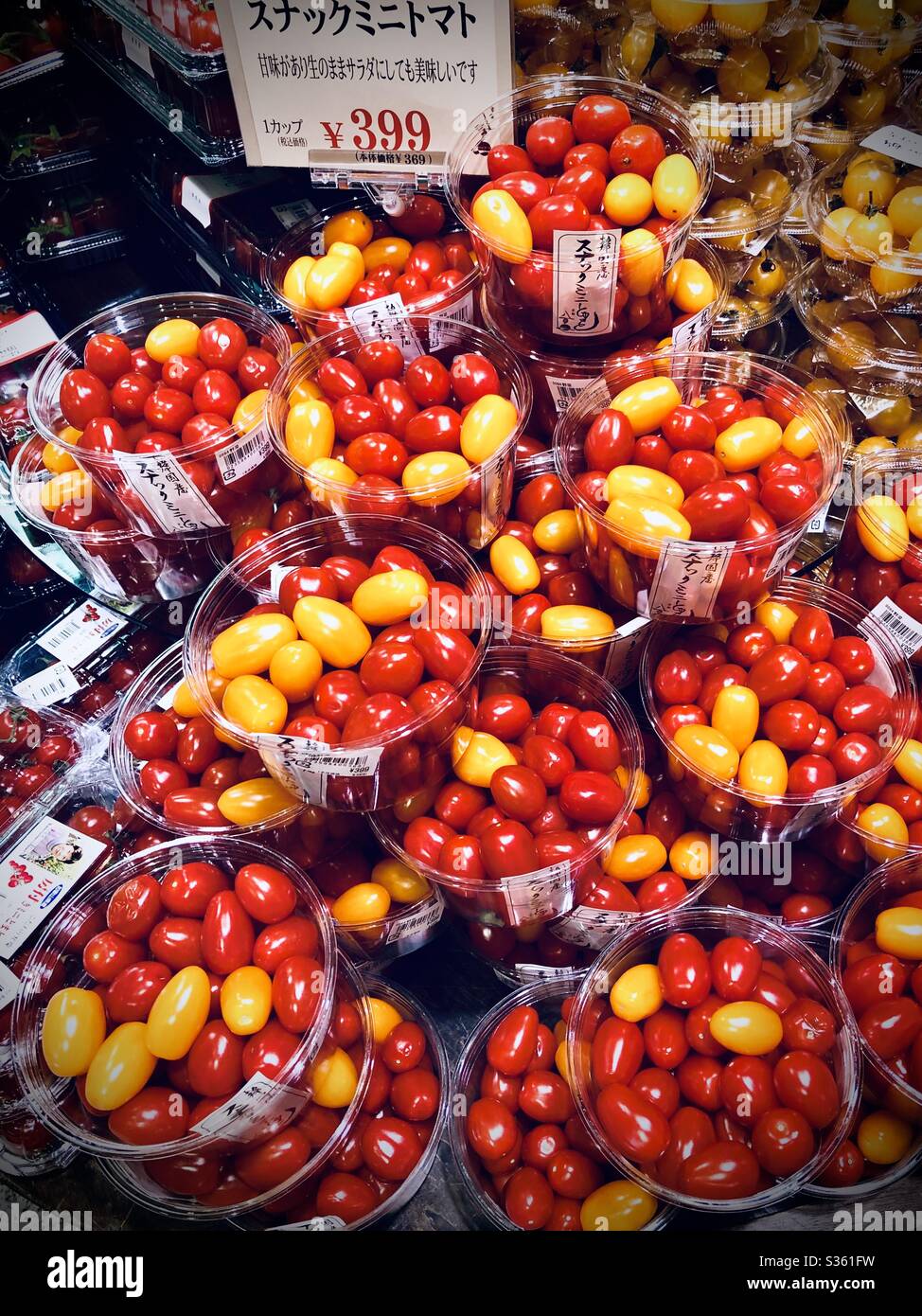 Pomodori ciliegini rossi e gialli in vendita in un supermercato giapponese Foto Stock