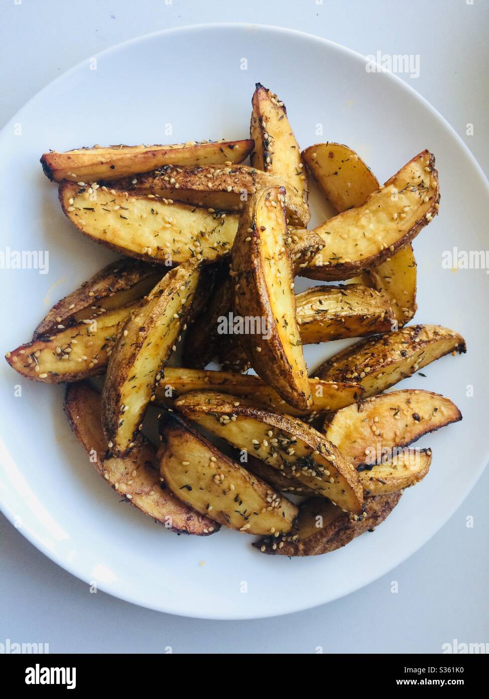 Zeppe di patate fatte in casa su un piatto bianco - Immagine stock catturata con smartphone
