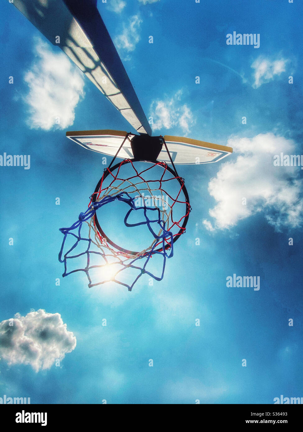 Rete da basket contro il cielo blu con il sole splendente attraverso la rete Foto Stock