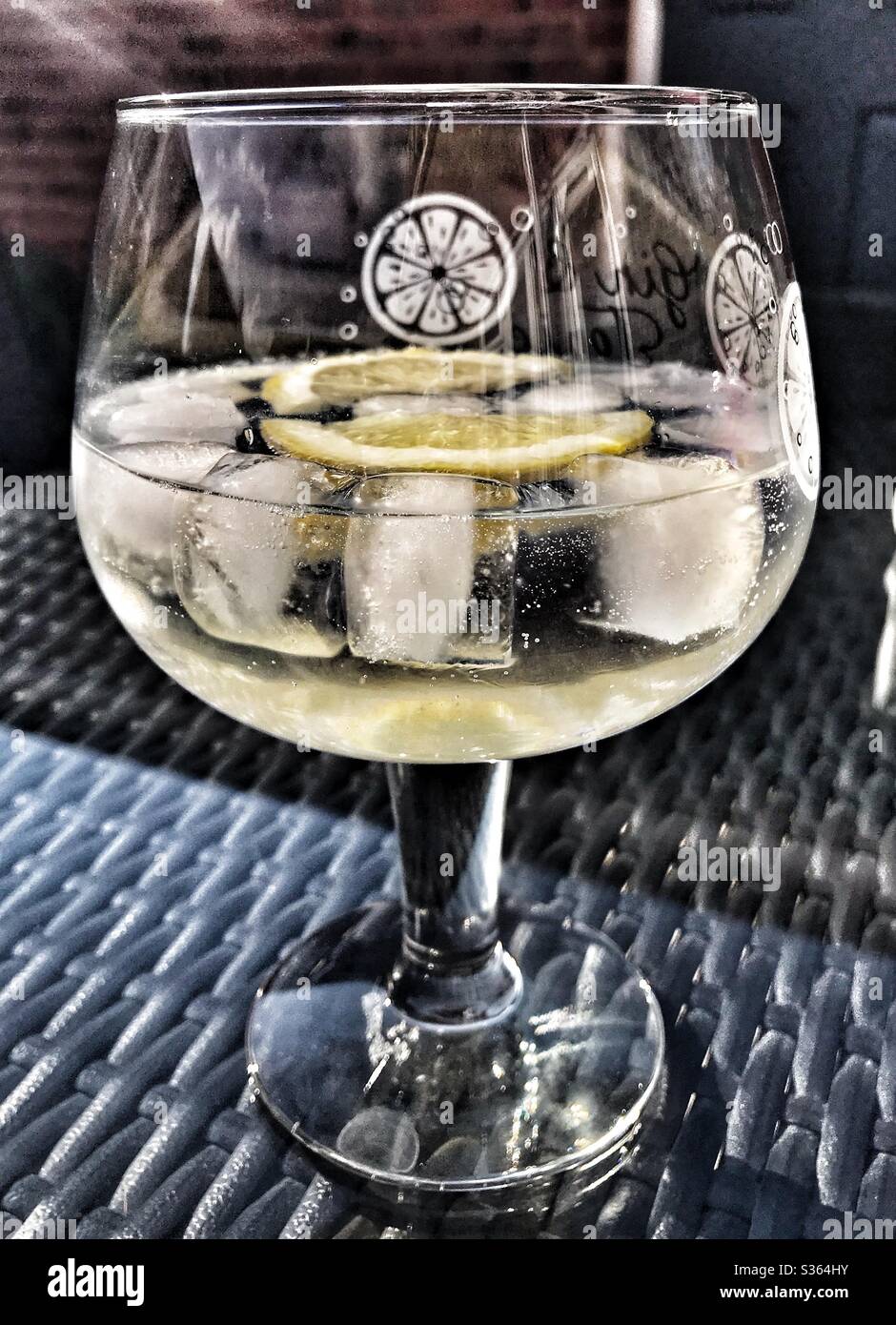 Bicchiere di Gin e Tonic con ghiaccio e una fetta di limone su un tavolo - Immagine stock catturata con smartphone Bicchiere di Gin e Tonic con ghiaccio e una fetta di limone su un tavolo - Immagine stock catturata con smartphone