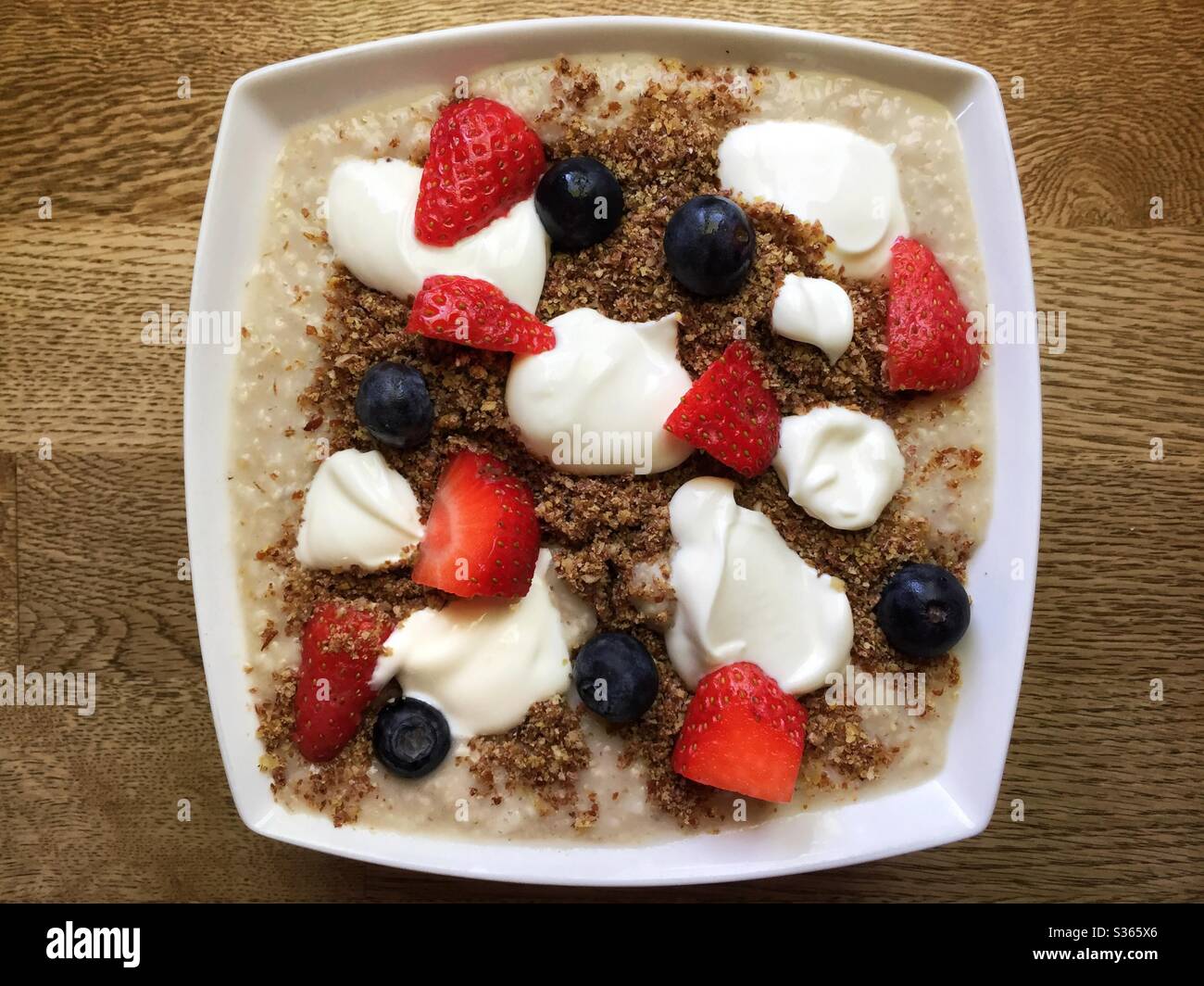 Porridge con fragole, mirtilli, semi di lino e yogurt Foto stock - Alamy