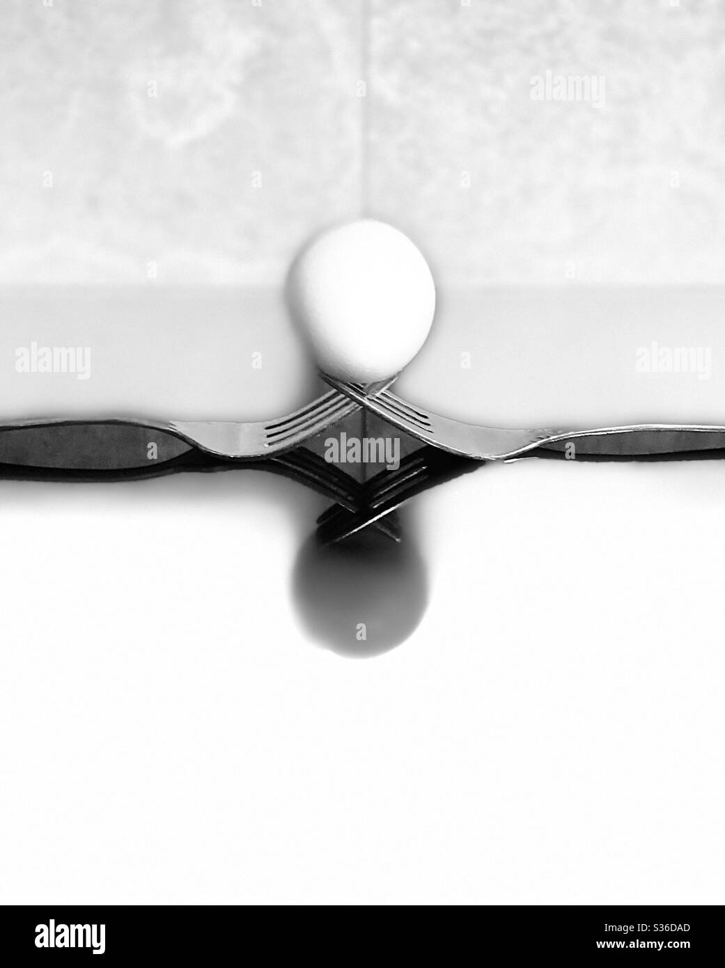 Fotografia creativa utilizzando le funzioni di ritratto di iPhone 11 Pro di un uovo su forchette con riflessi sulla superficie Foto Stock