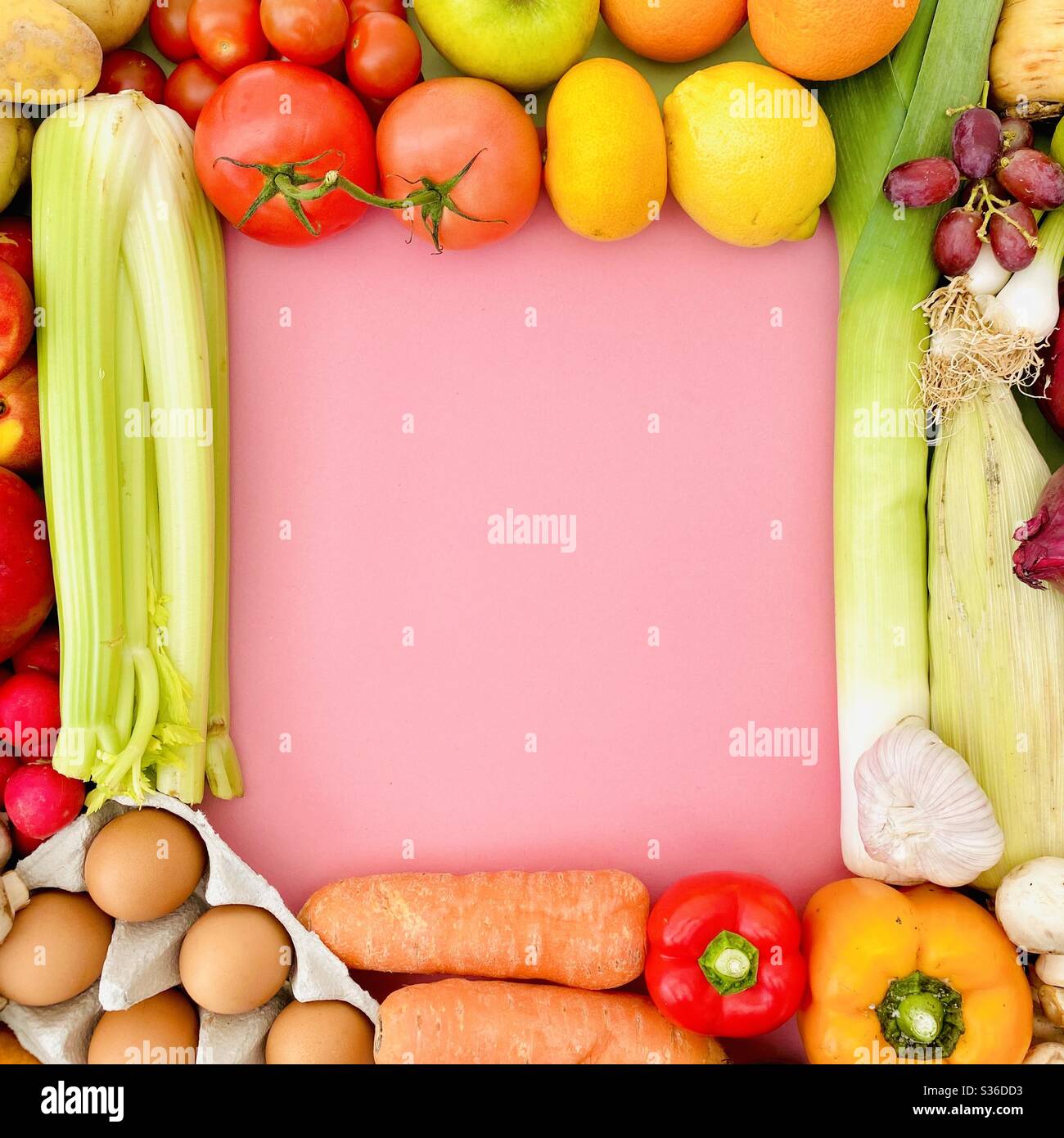Frutta e verdura vivaci e colorate creano una cornice quadrata con spazio di copia su uno sfondo rosa pastello. Cibo fresco e biologico da un mercato agricolo locale. - Immagine stock catturata con smartphone
