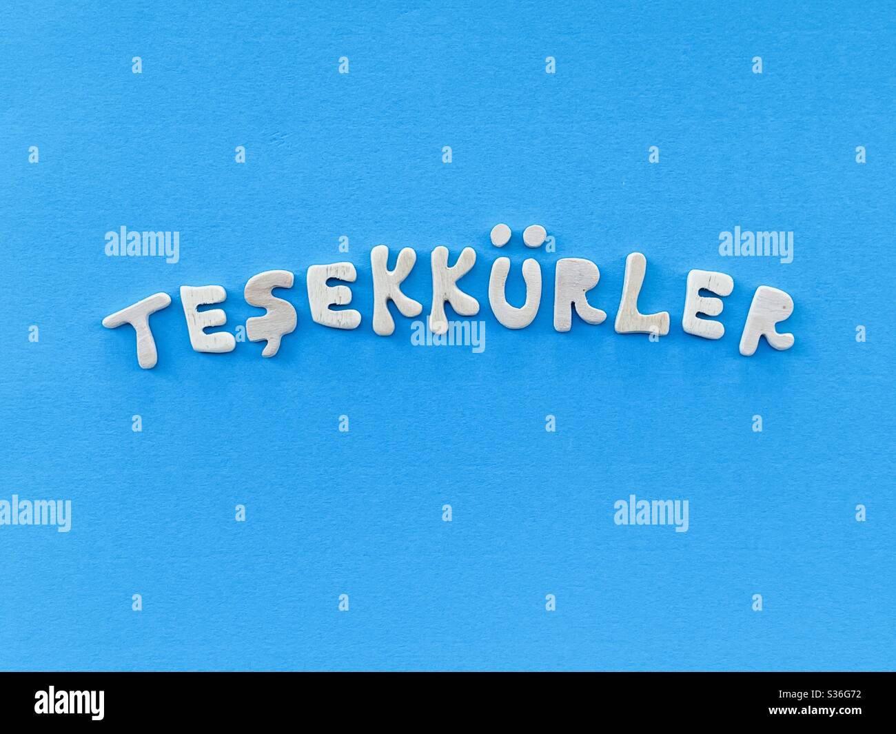 Teşekkürler, grazie in lingua turca composto da lettere in legno fatte a mano su colore blu Foto Stock
