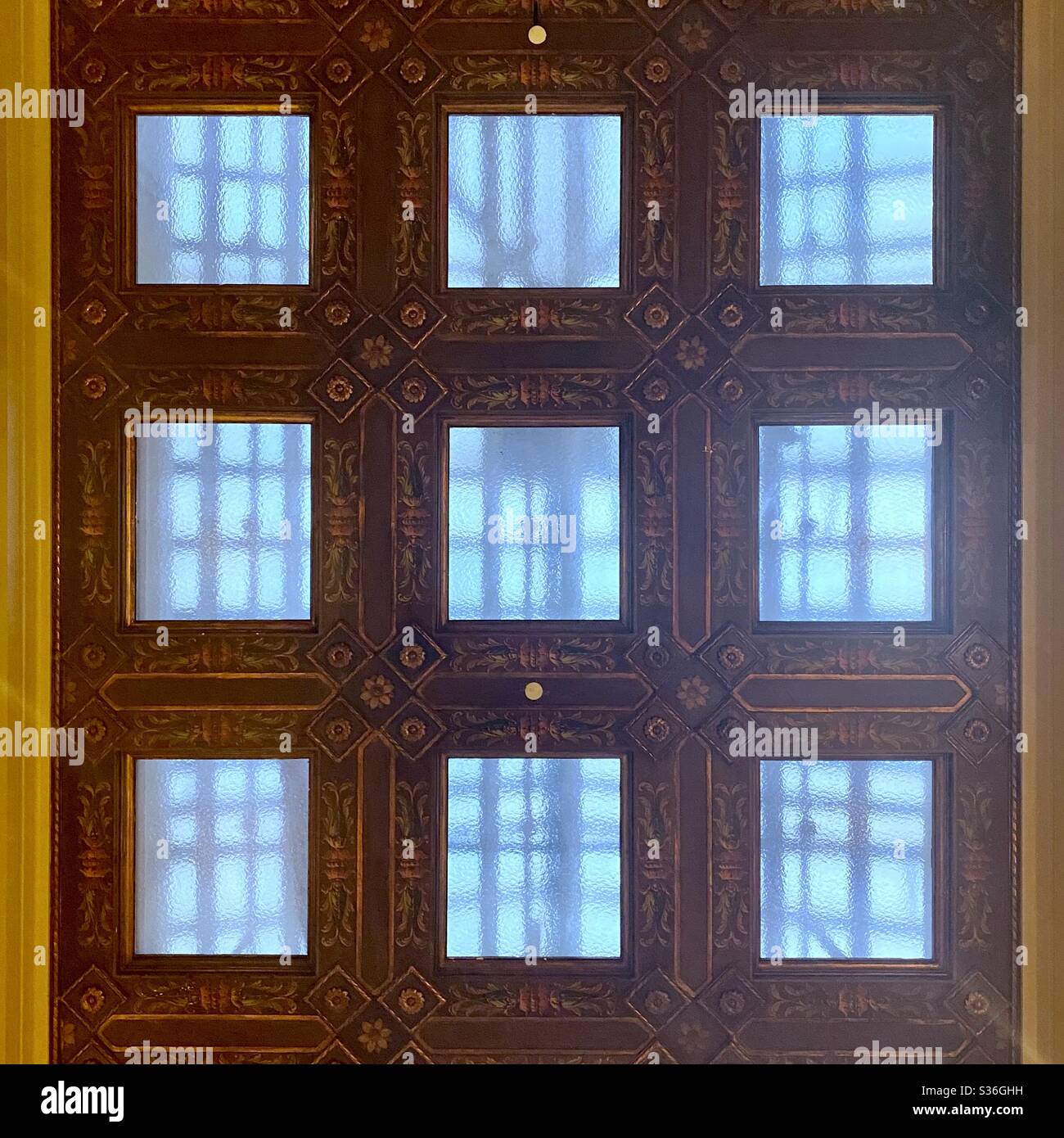 Particolare di finestra decorativa sul soffitto, illuminata con tungsteno sotto e luce blu proveniente dall'alto Foto Stock