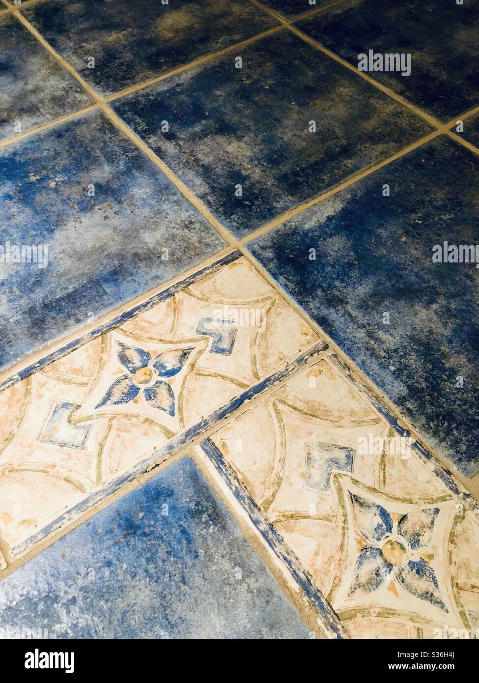 Piastrelle in ceramica blu e piastrelle dipinte assortite con un disegno floreale geometrico con beige e giallo. Design per interni - Immagine stock catturata con smartphone