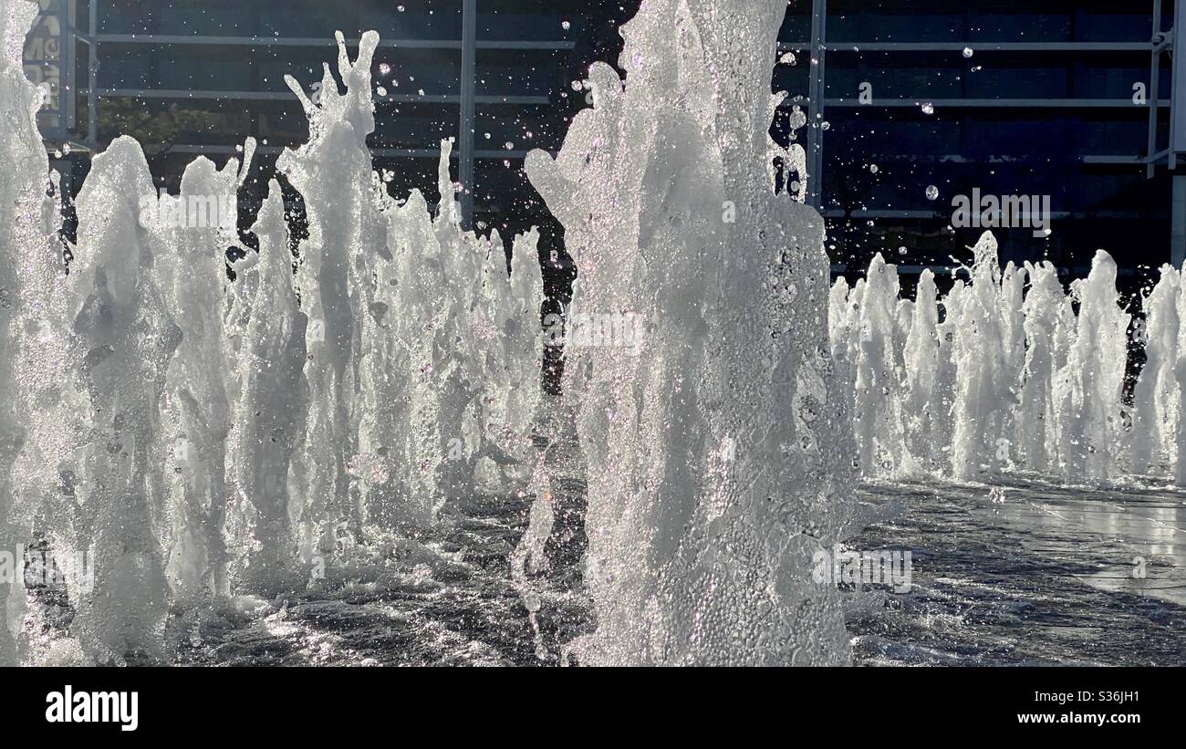 Vista laterale della fontana, spruzzando verso l'alto su sfondo scuro, ripresa con alta velocità dell'otturatore - Immagine stock catturata con smartphone
