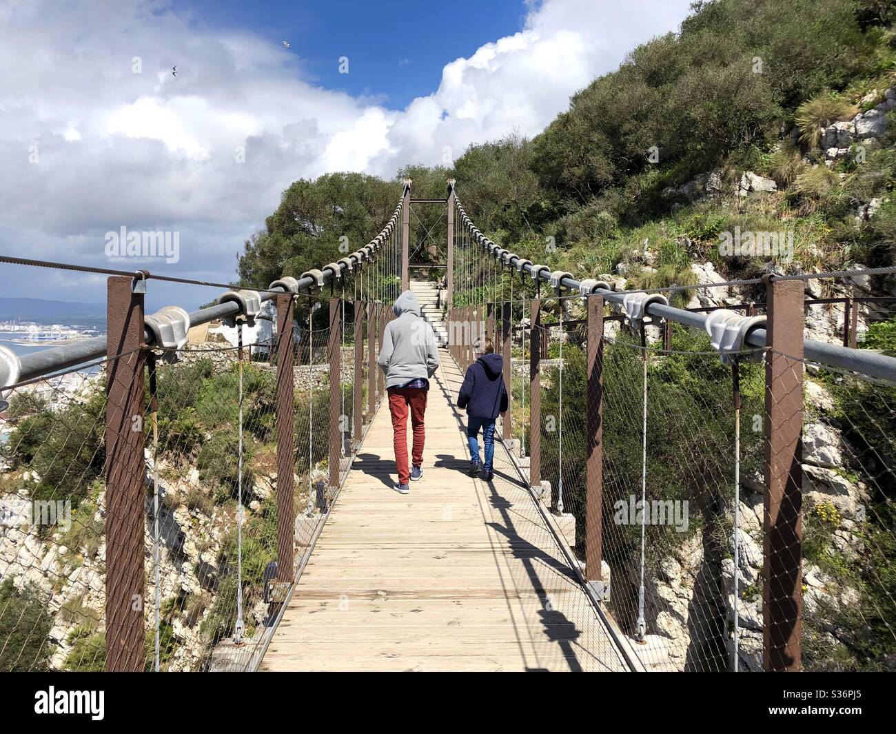 Due bambini che attraversano il ponte sospeso di Gibilterra - Immagine stock catturata con smartphone Due bambini che attraversano il ponte sospeso di Gibilterra - Immagine stock catturata con smartphone