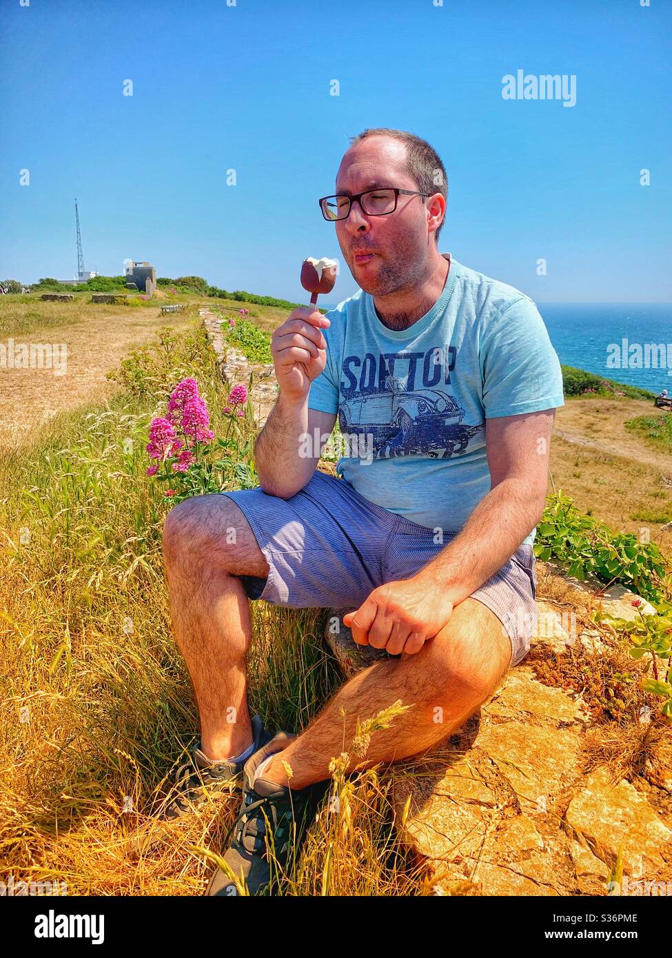 Uomo che mangia un gelato con uno sfondo naturale piuttosto. - Immagine stock catturata con smartphone