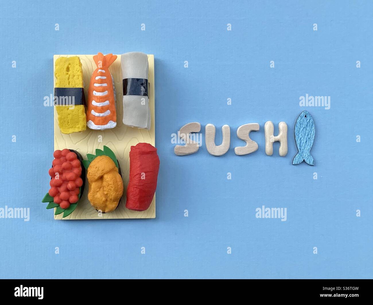 Tempo di sushi con una composizione creativa di cibo giapponese e lettere di legno fatte a mano con un disegno di pesce Foto Stock