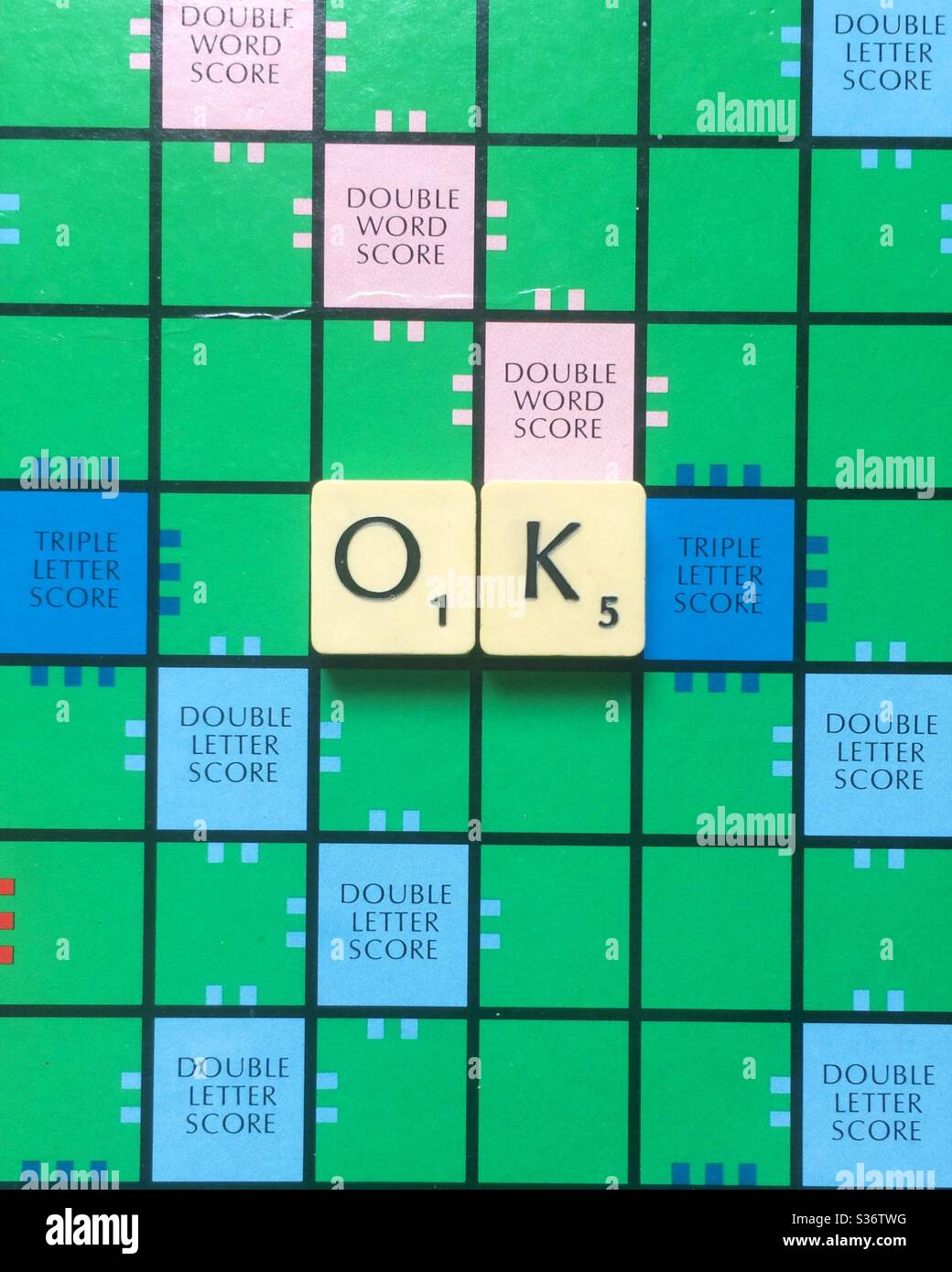 La parola OK si è formata con piastrelle Scrabble su un tavolo di gioco Scrabble Foto Stock