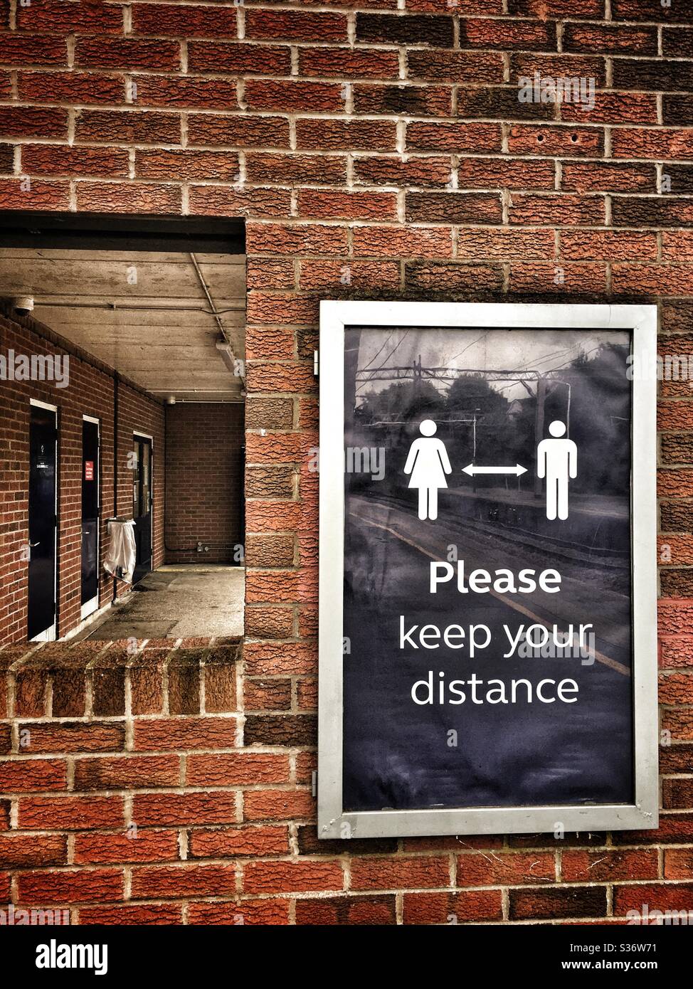 Si prega di tenere il poster della distanza sulla stazione ferroviaria UK Foto Stock