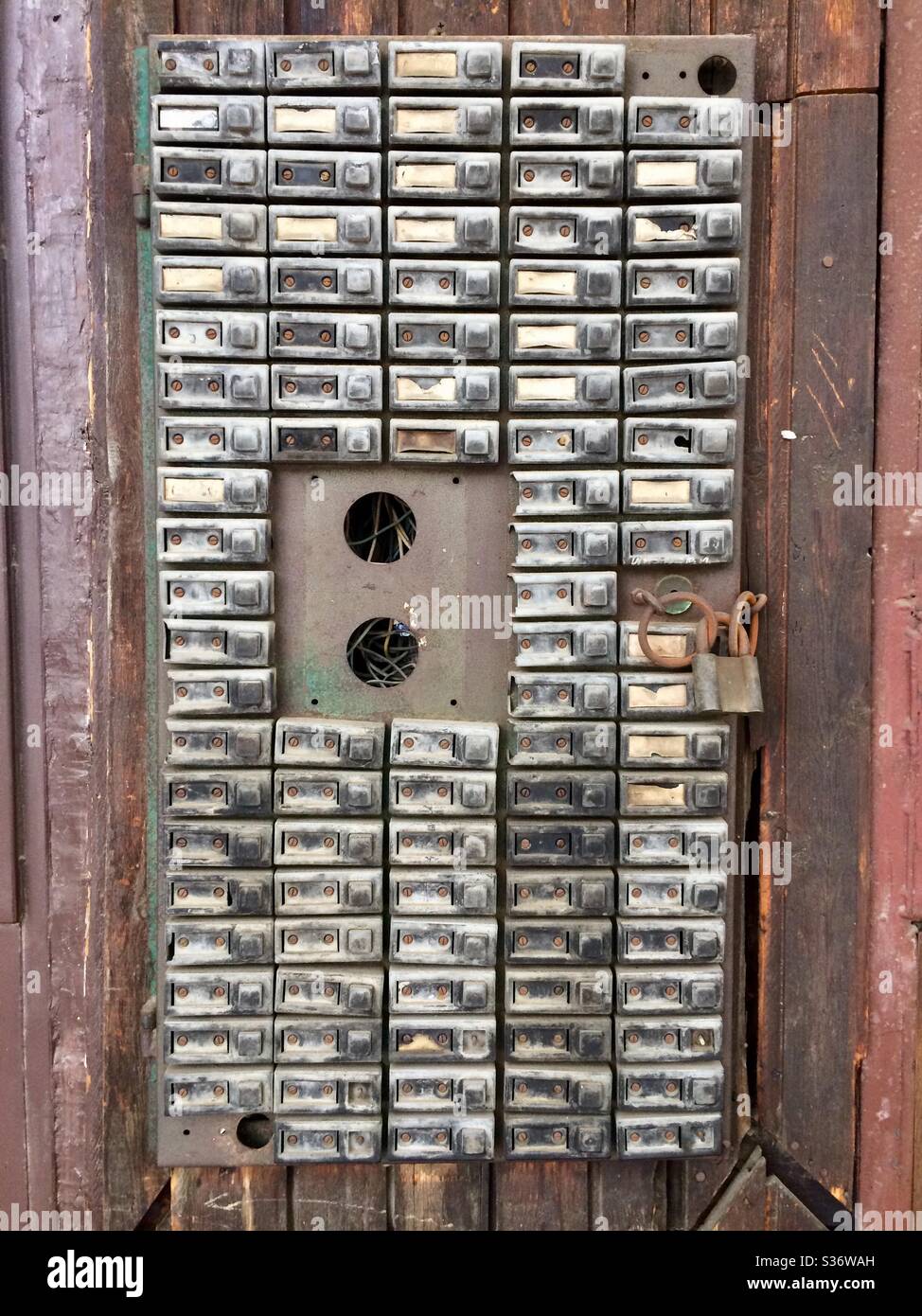 Campanelli per appartamenti vecchi campanili in disuso o campanelli per call box su facciata in legno, fila di campanelli - Immagine stock catturata con smartphone