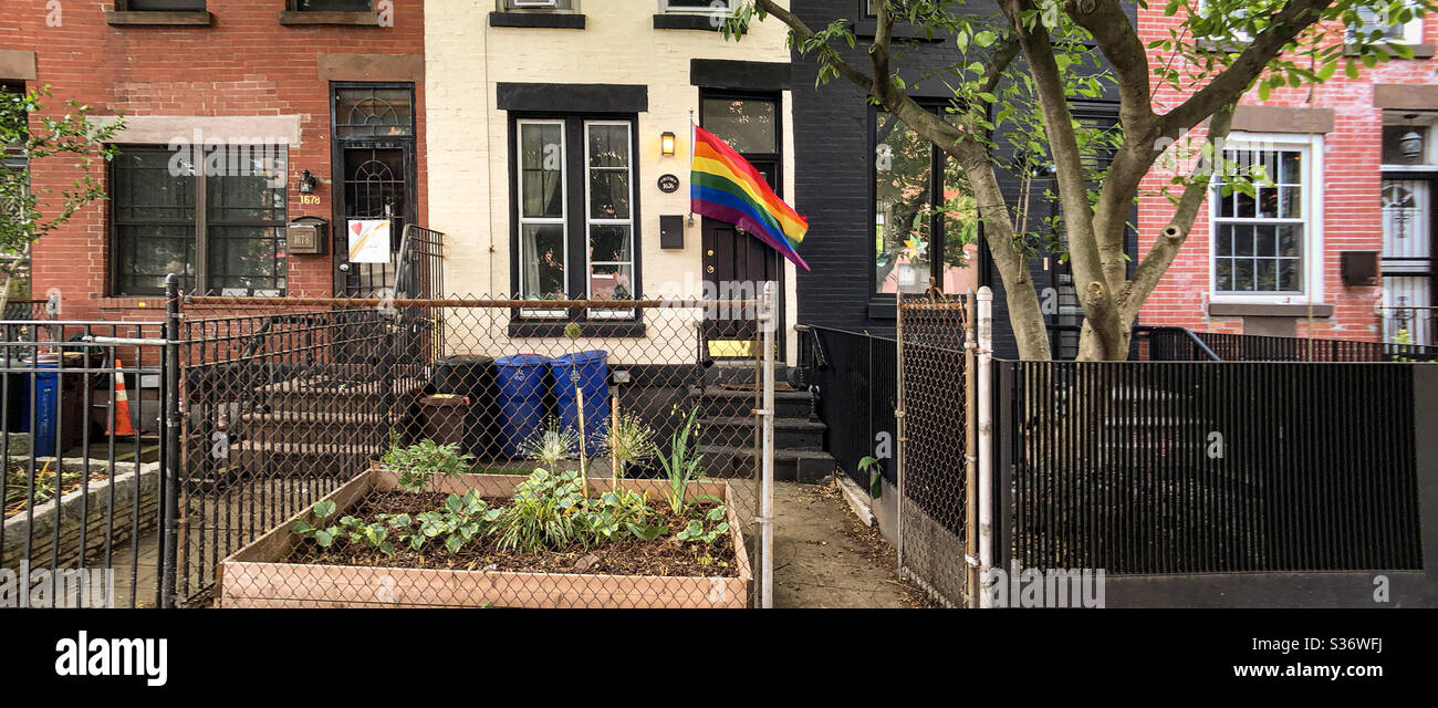 Bandiera Rainbow LGTB sul portico anteriore di una graziosa piccola casa cittadina a Park Slope, Brooklyn, che celebra il mese dell'orgoglio Foto Stock