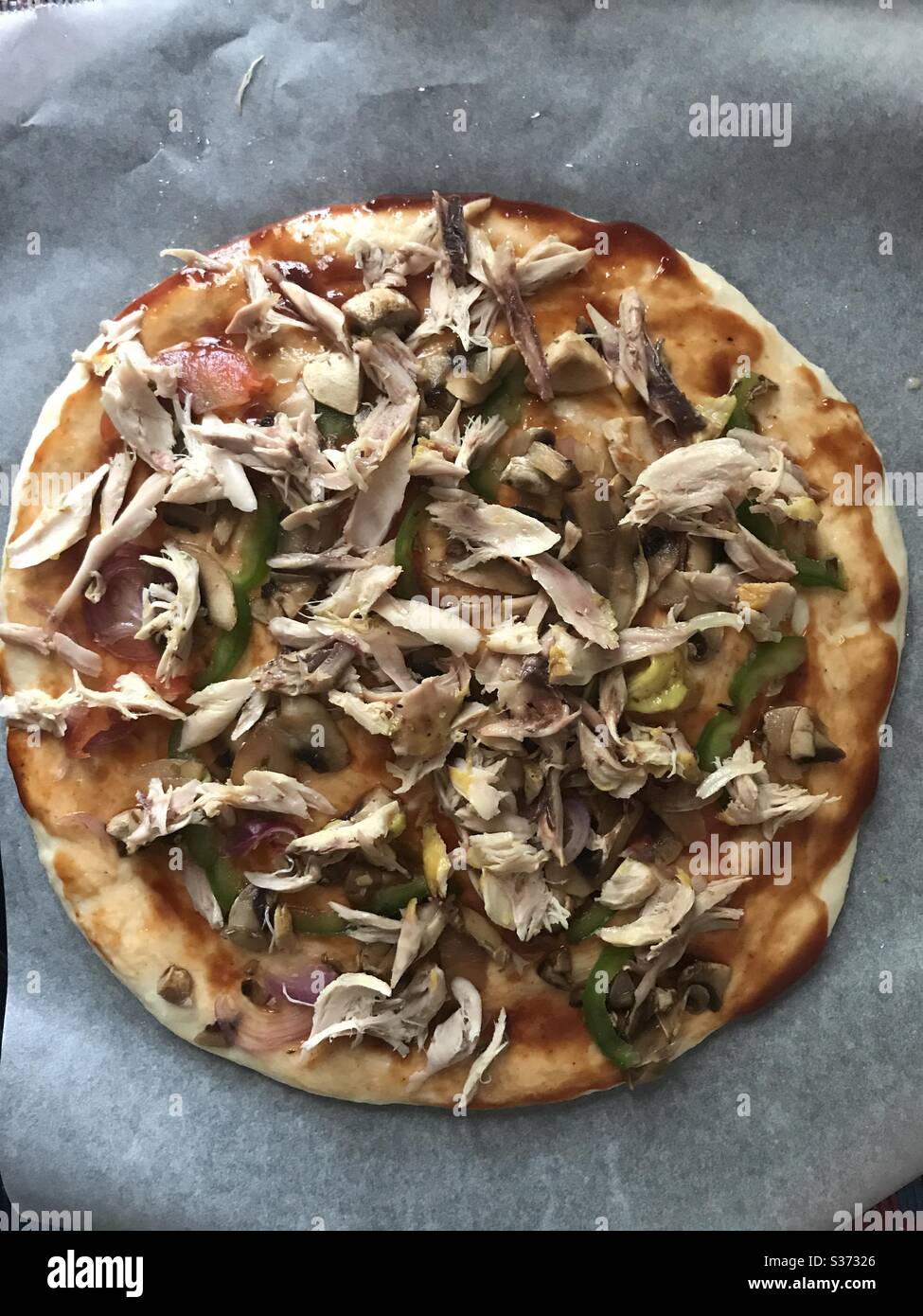 Pizza da cucina: I condimenti sulla pizza vengono fatti attendere che il formaggio venga spruzzato e poi direttamente al forno caldo Foto Stock