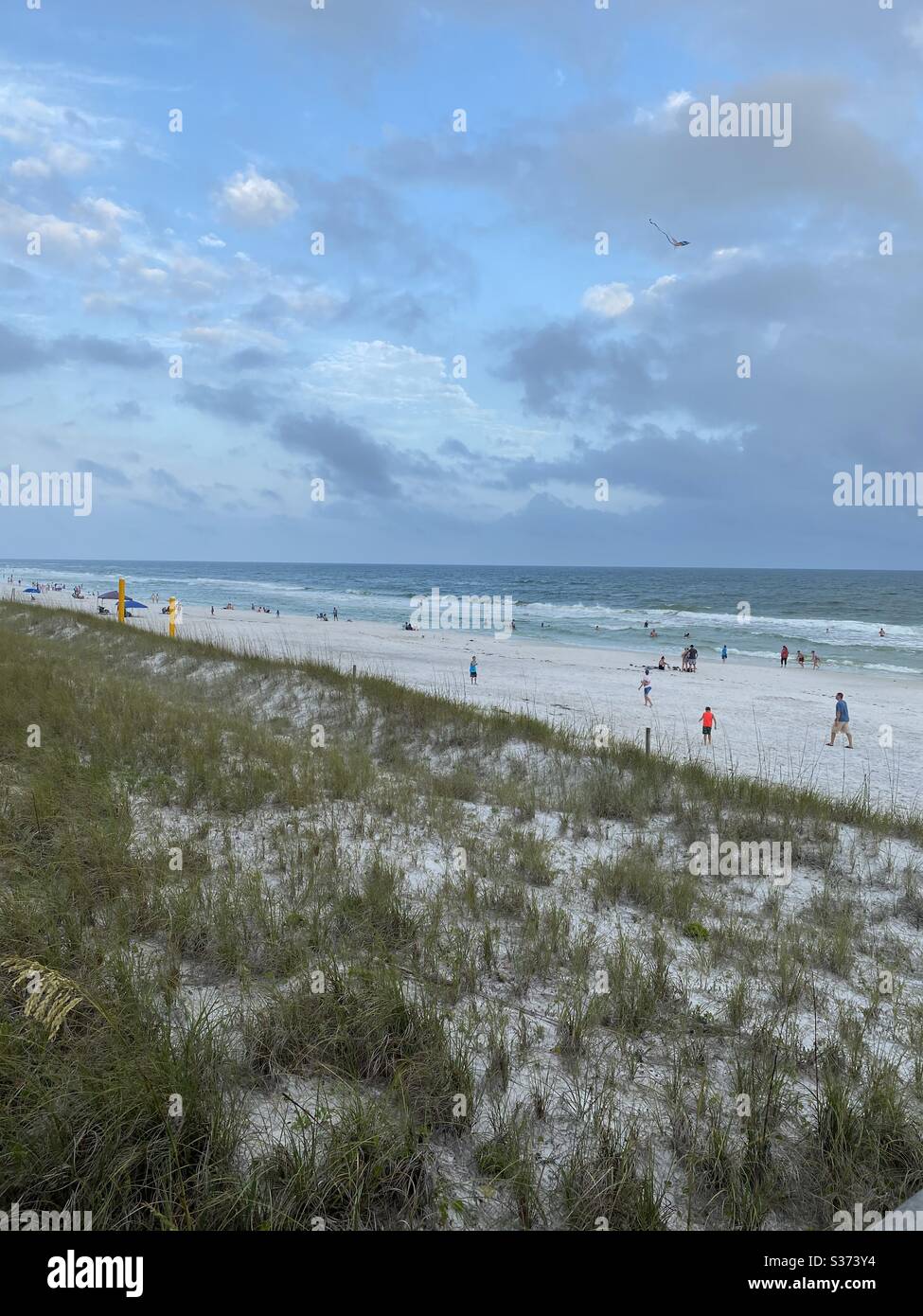 Vista superiore delle dune di sabbia bianca e della spiaggia con vista distante delle persone sulla spiaggia e dell'acqua color smeraldo - Immagine stock catturata con smartphone