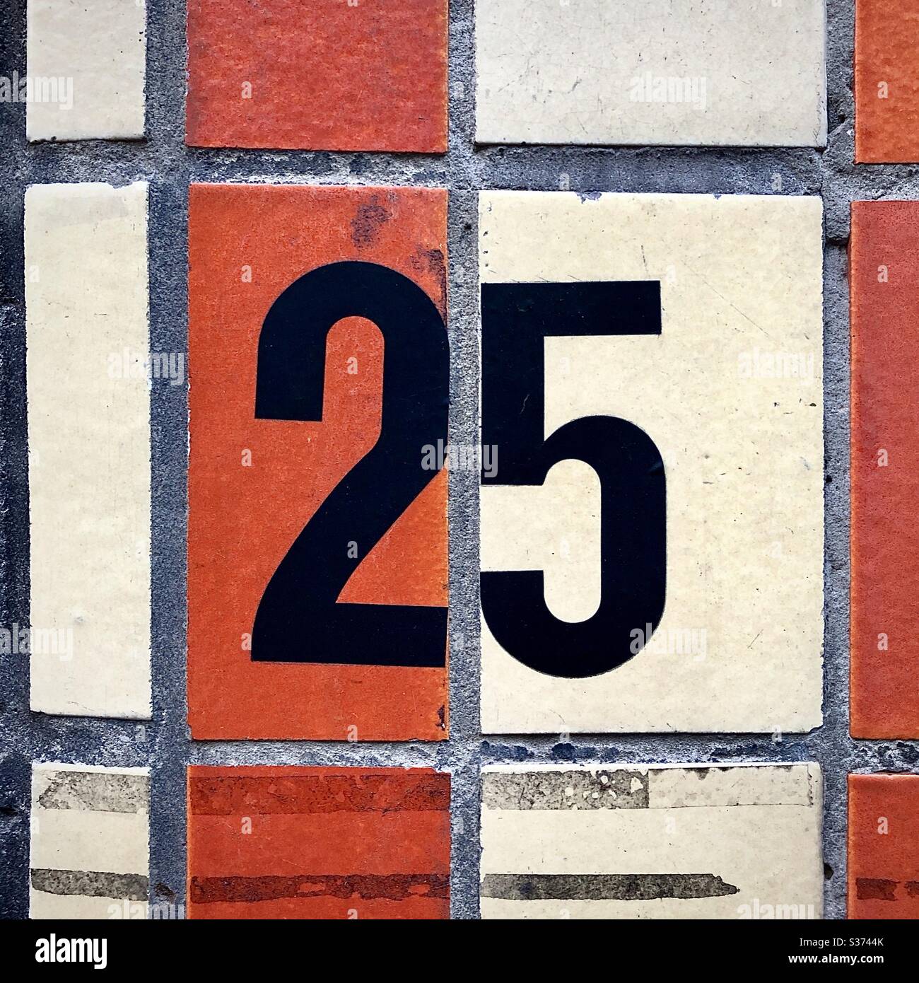 Casa numero "25" con figure a pressione in plastica su piastrelle di strada a Bruxelles, Belgio. - Immagine stock catturata con smartphone