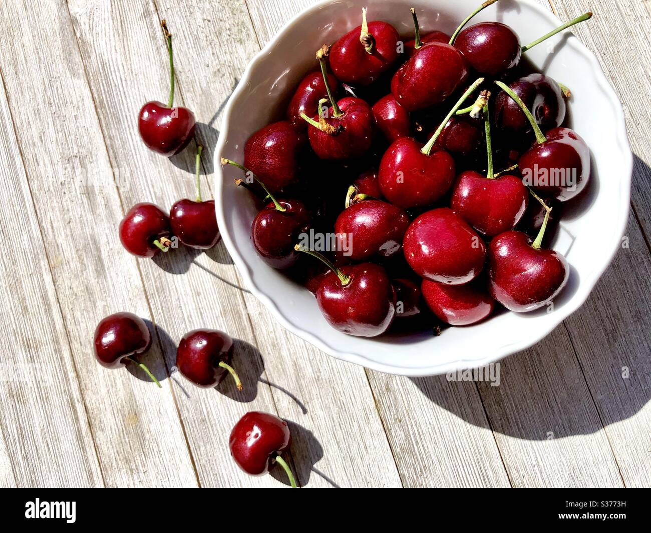 Ciotola di ciliegie su una superficie di legno Foto Stock