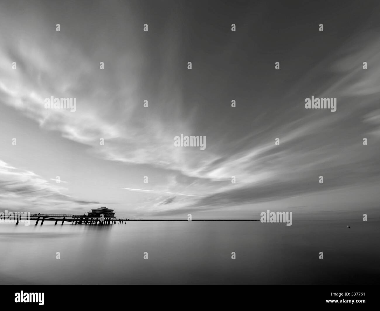 Bianco e nero esposizione lunga di acqua di mare e nuvole Foto Stock