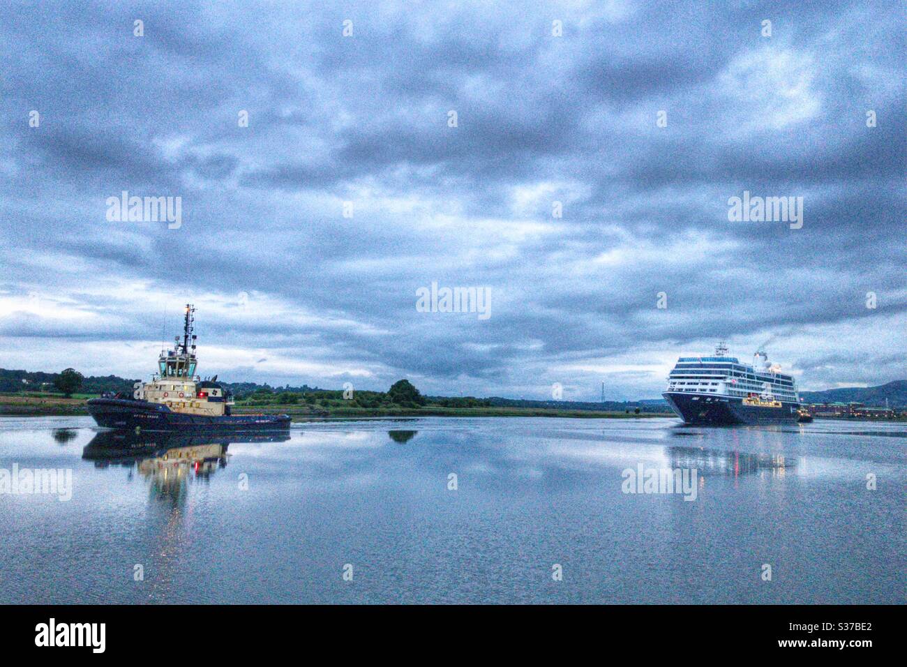 Azamara quest e rimorchiatore navigando lungo il fiume Clyde. Foto Stock