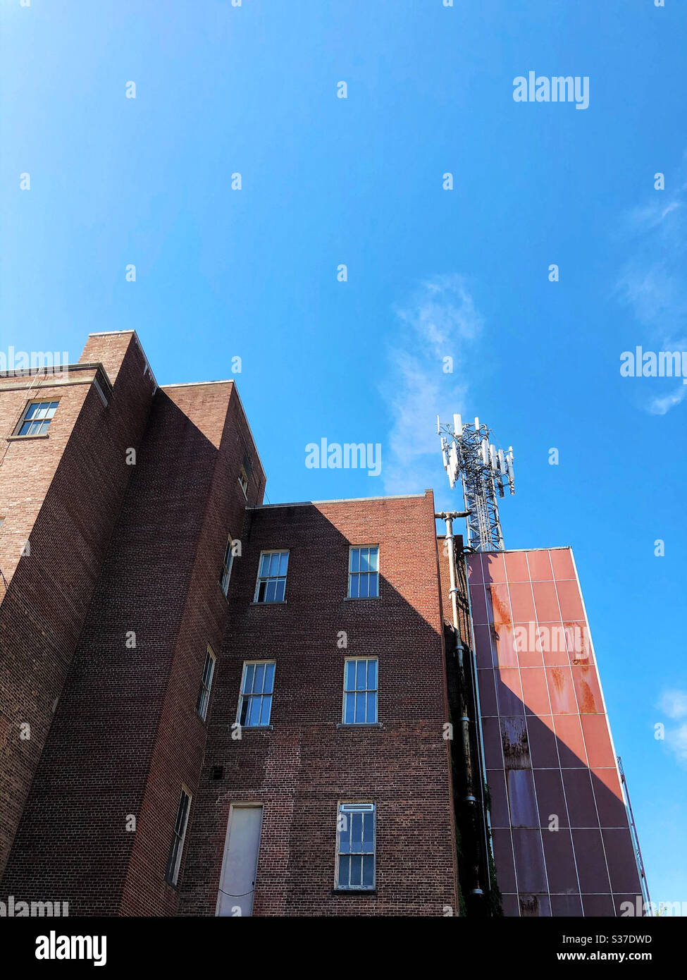 Edificio in città con un array di torri per telefoni cellulari montato sulla parte superiore Foto Stock