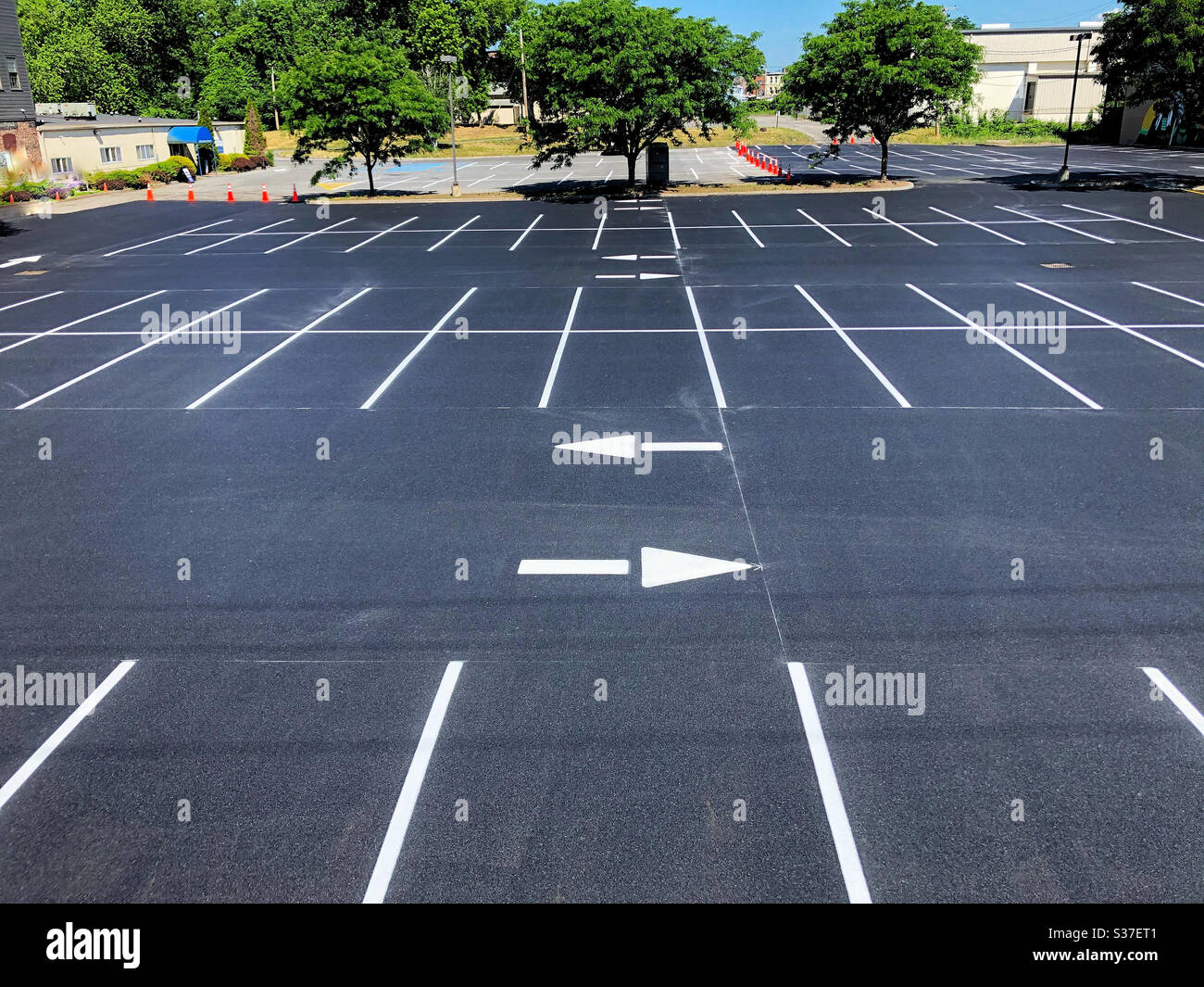 Parcheggio nuovo di zecca con fresco dipinto bianco per delineare i parcheggi e le frecce direzionali - Immagine stock catturata con smartphone