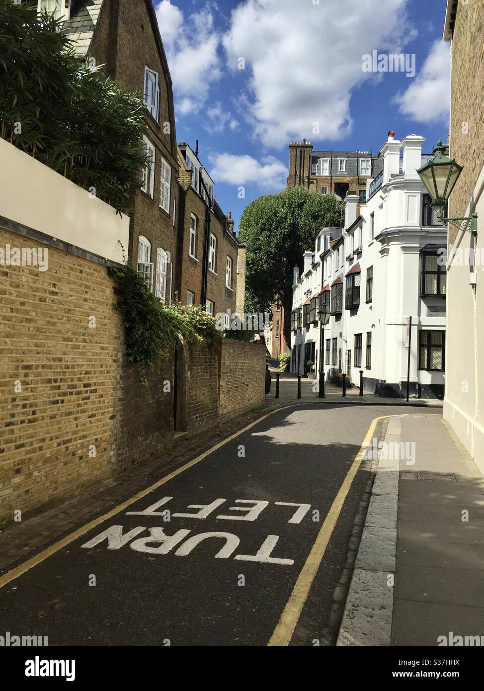 Svolta a sinistra scritta sul terreno della tipica strada londinese in un quartiere ricco a causa del traffico a sinistra Foto Stock