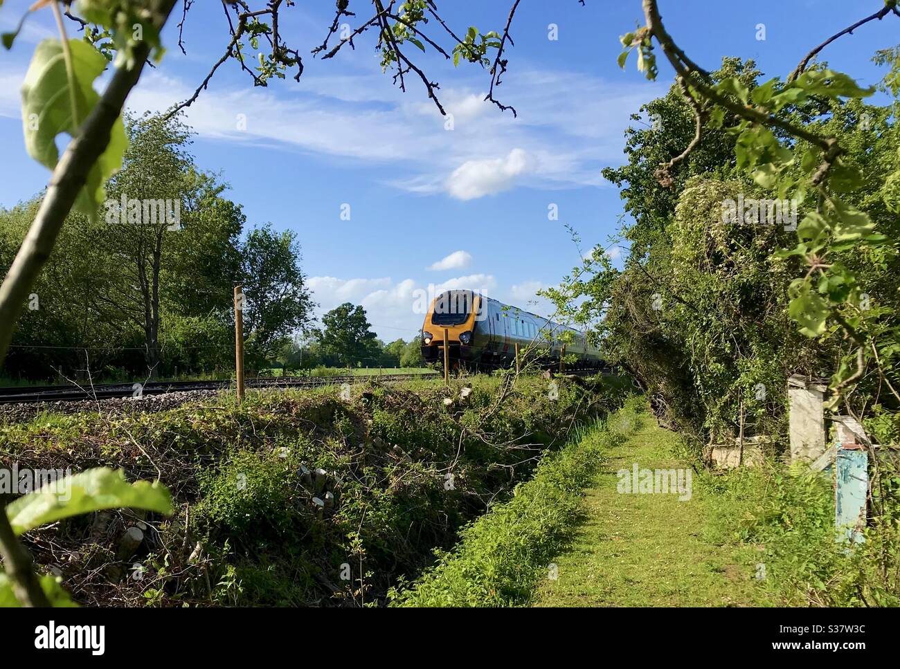 Un treno passa davanti a un giardino Oxfordshire. Foto Stock