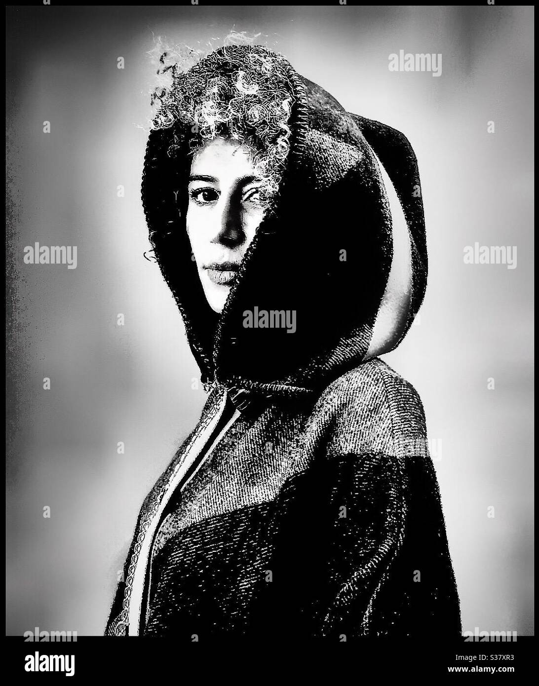 Un modello indossa un cappotto con cappuccio. Foto Stock