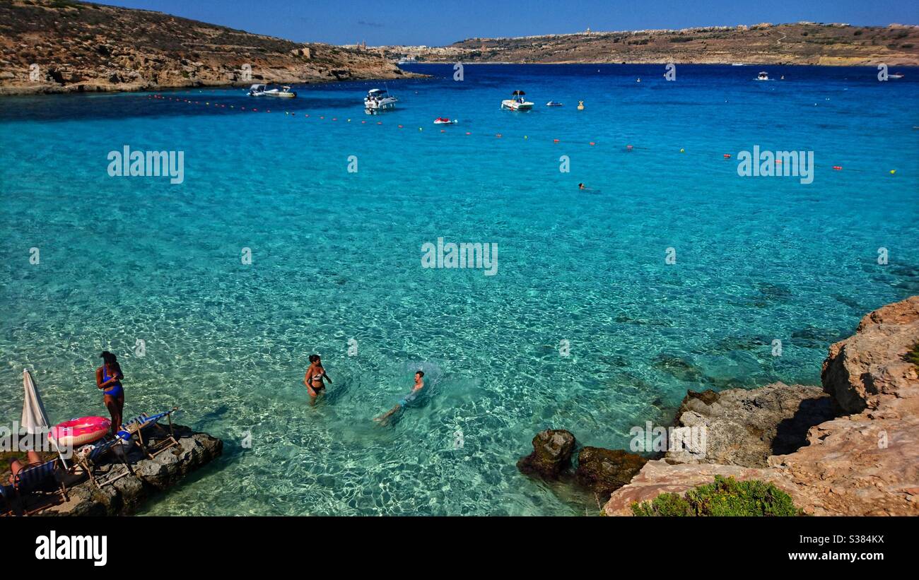 Una fotografia di turisti che si godono la Laguna Blu a Gozo, Malta. Destinazione di vacanza. Sole, mare e sabbia. Foto Stock