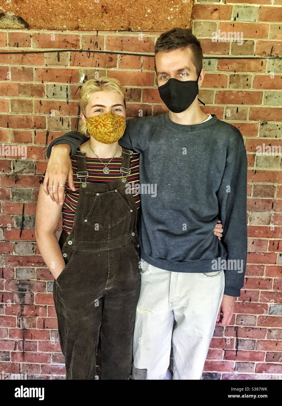 Giovane coppia che indossa maschere per il viso Foto Stock