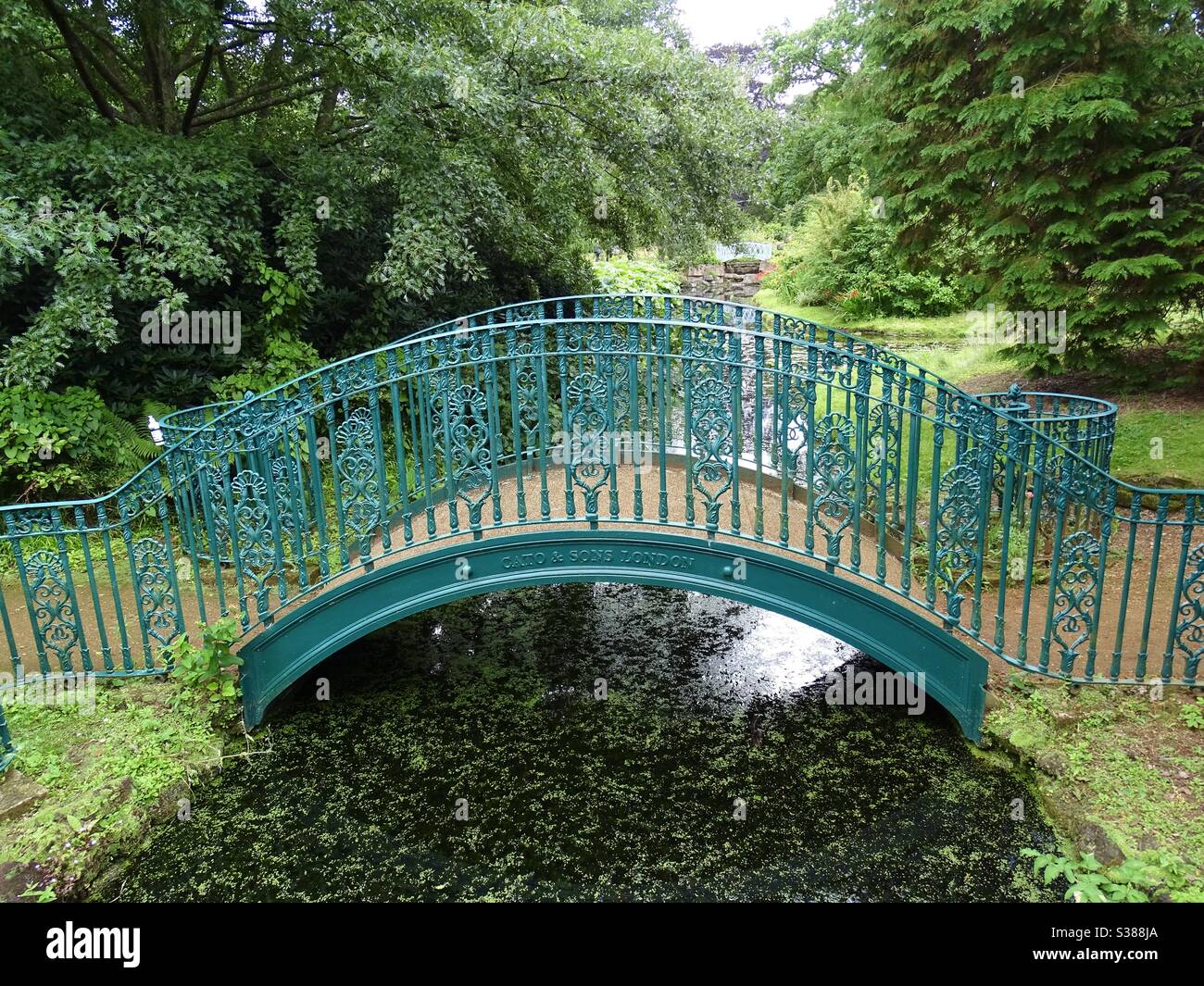 Ponte verde ornato su un fiume in un parco in Inghilterra Foto Stock