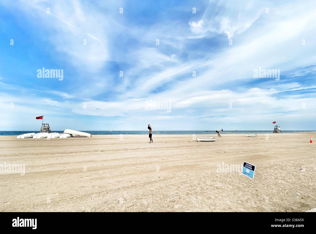 Bagnino di addestramento e di esercizio su una spiaggia vuota al lago Michigan a causa di esso è chiuso. Foto Stock