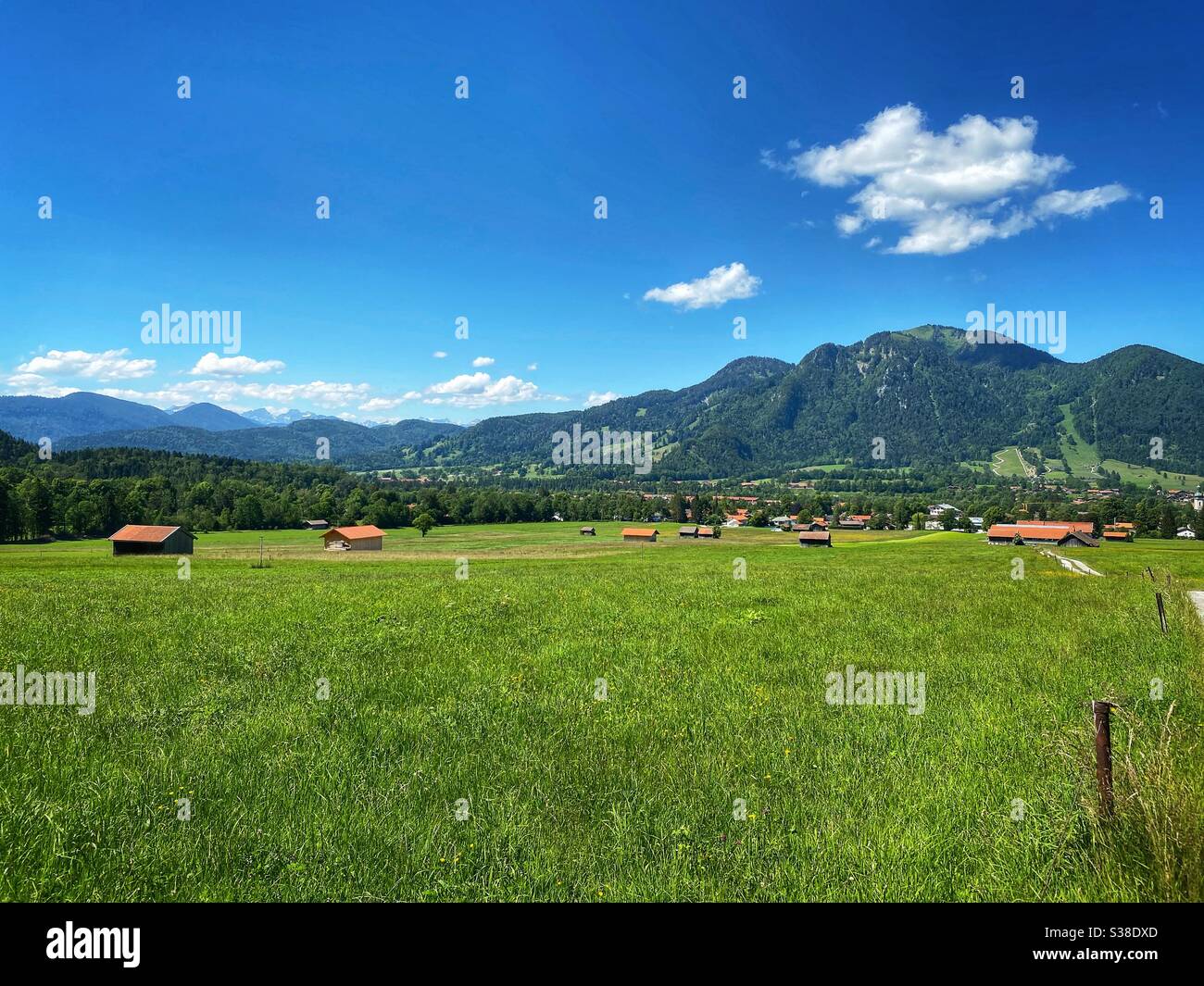 Prati alpini con le Alpi Bavaresi e austriache e la montagna Brauneck sullo sfondo. - Immagine stock catturata con smartphone