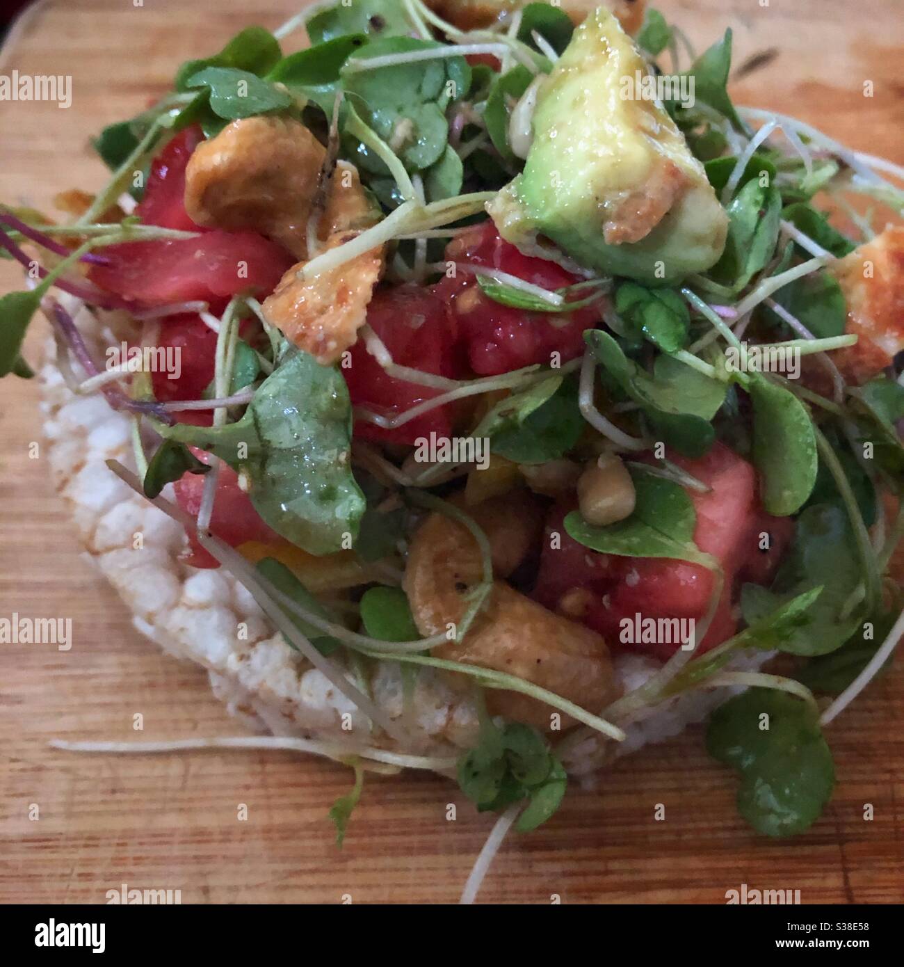 Panino aperto con hummus, pomodoro, avocado, cashews e micro green. Foto Stock