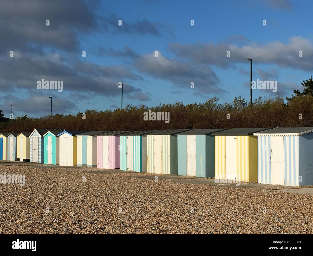 Linea di capanne da spiaggia multicolore a strisce Foto Stock