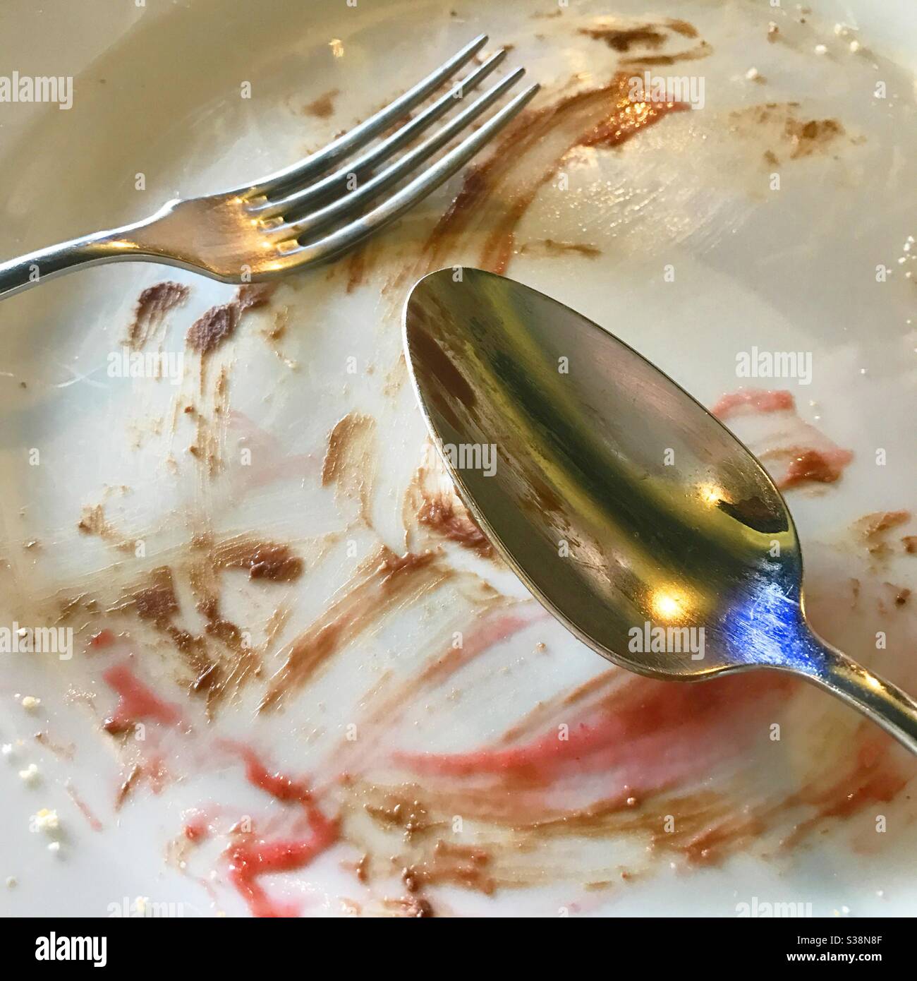 Cucchiaio e forchetta su piastra vuota. - Immagine stock catturata con smartphone