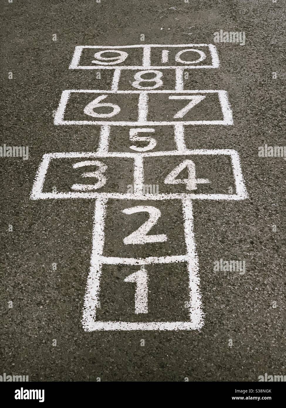 Numeri uno a dieci dipinte su un parco giochi da fare Il gioco Hopscotch Foto Stock