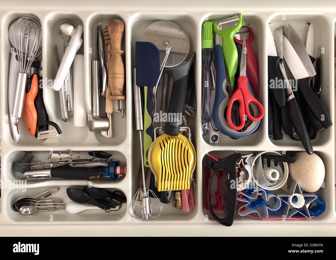 Pasticcio nel cassetto delle posate. Vista dall'alto di vari utensili da  cucina senza organizzazione. Predominanza del colore arancione Foto stock -  Alamy